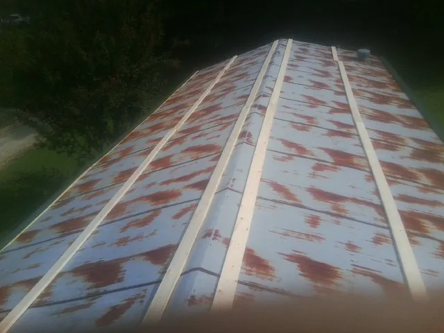 Rusted metal roof panels with new wood purlins before replacement — Storm Damage Roof Repair in Linwood by Roofing Brothers